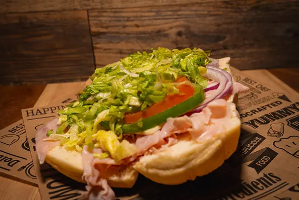 Sub sandwich with lettuce, tomato, and onion.
