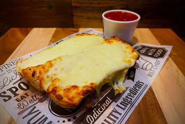 Cheesy bread with marinara sauce on tray.