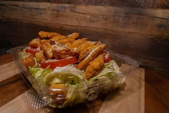Chicken salad with tomatoes in plastic container.