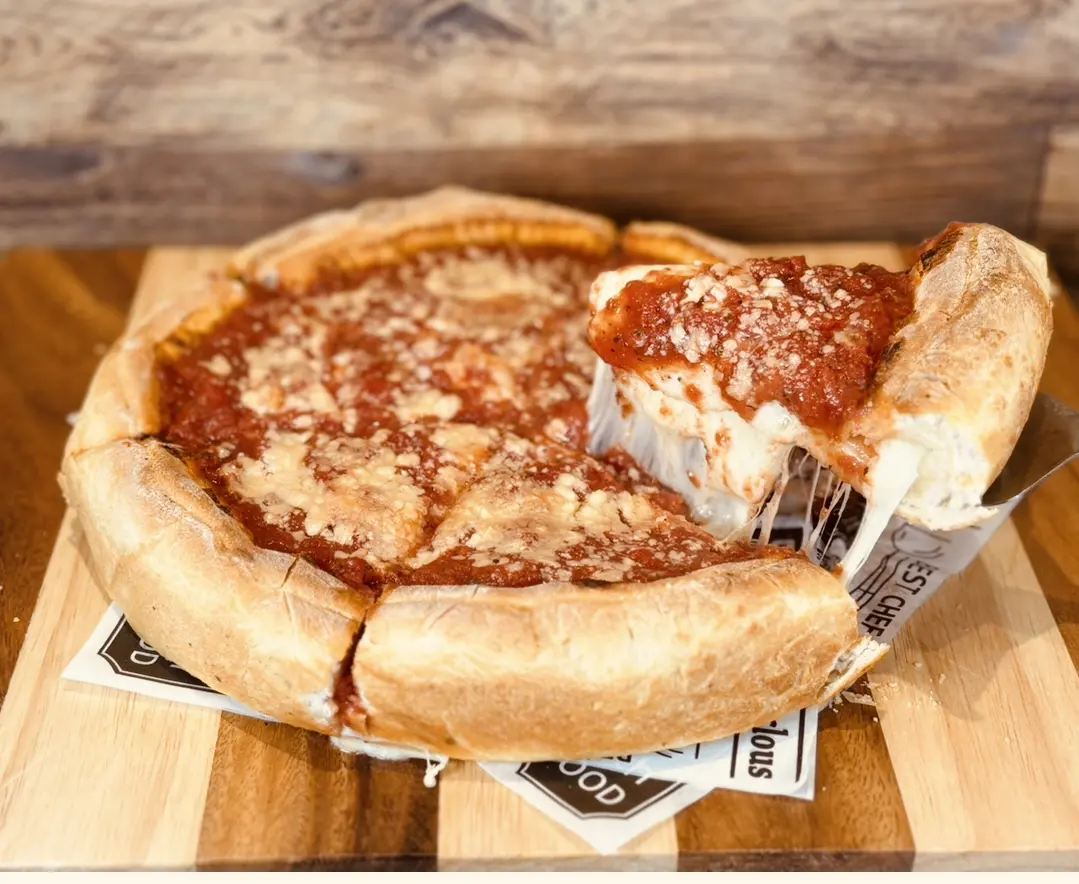 Deep dish pizza with cheese pull slice.