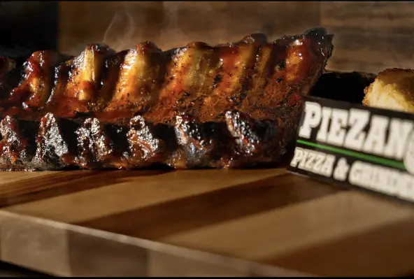 Barbecued ribs on wooden board, PieZano's sign.