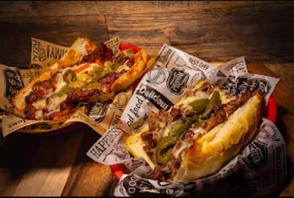 Sandwiches with meat and jalapeños on paper.