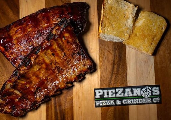 Barbecue ribs with bread on wooden board.